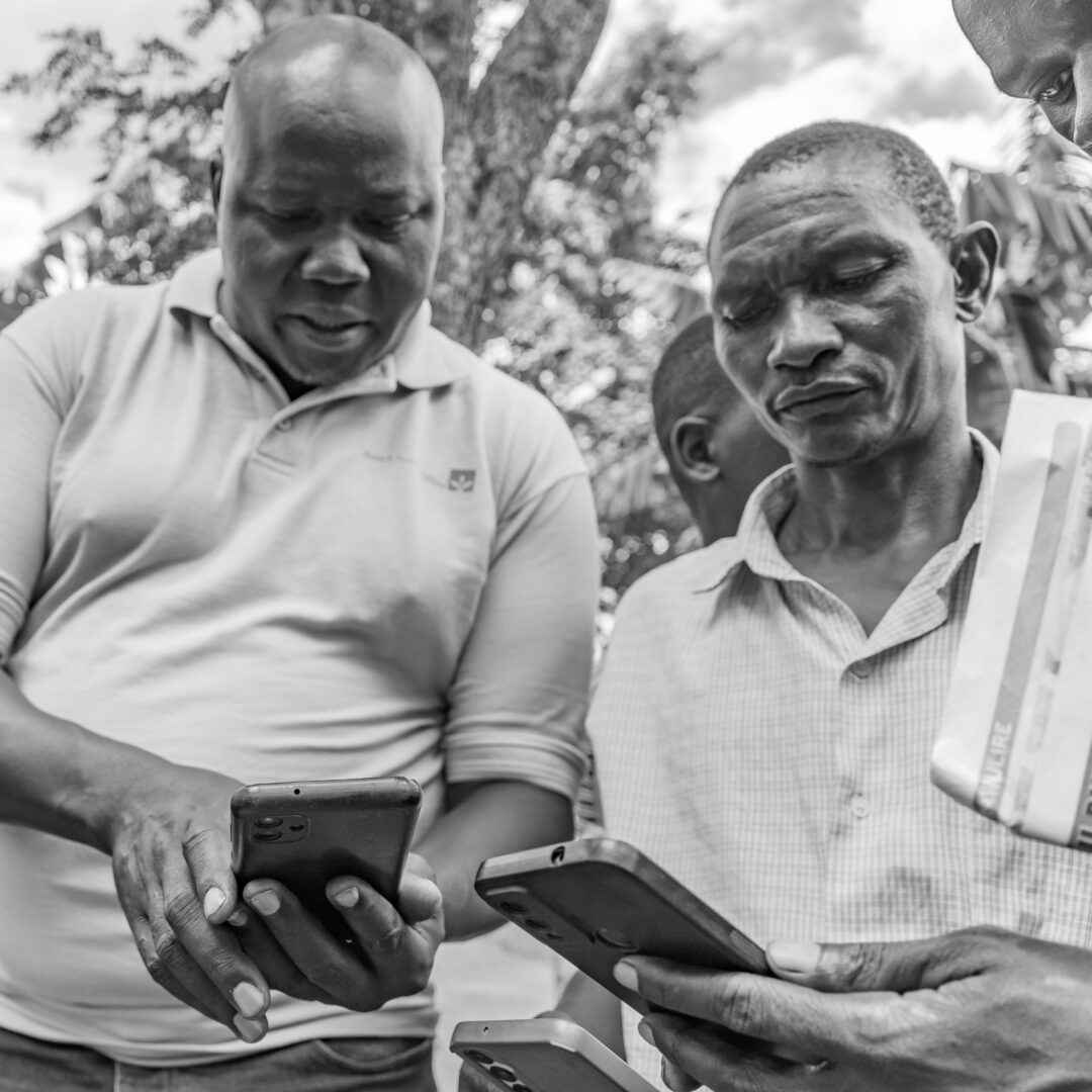 Two men are looking at their smartphones.